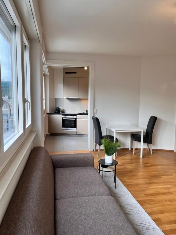 a living room with a couch and a kitchen at Luxury Studio Near UN & Train Station in Geneva
