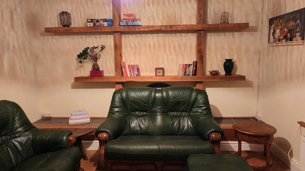 uma sala de estar com uma cadeira de couro e livros em Large 2 Bed Holiday Let in Central Ystradgynlais em Ystradgynlais
