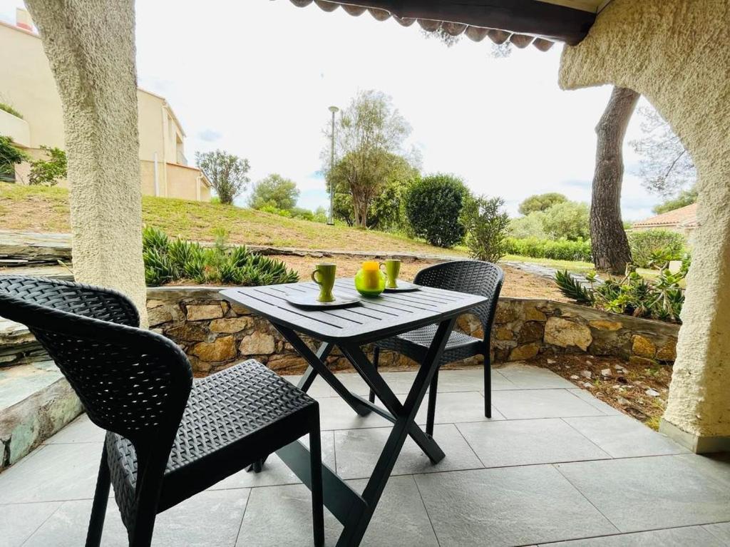 une table et des chaises assises sur une terrasse dans l'établissement Studio Cocody 1 Lumio, à Lumio