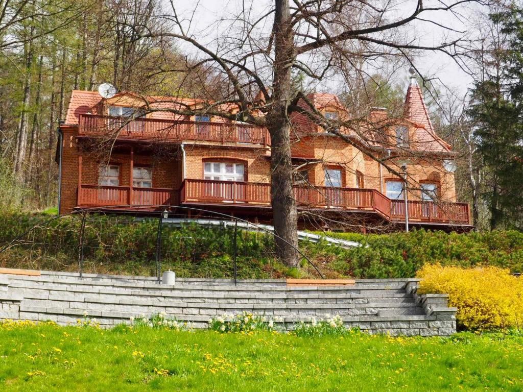 uma casa velha com um deque numa colina em Apartament Piękna 4 em Jedlina-Zdrój