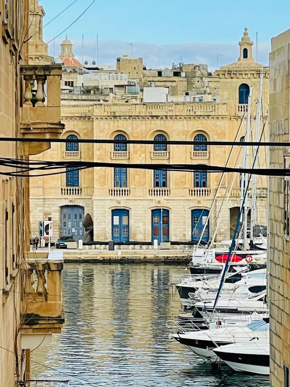 a group of boats in the water in front of a building at La Bambina in Senglea