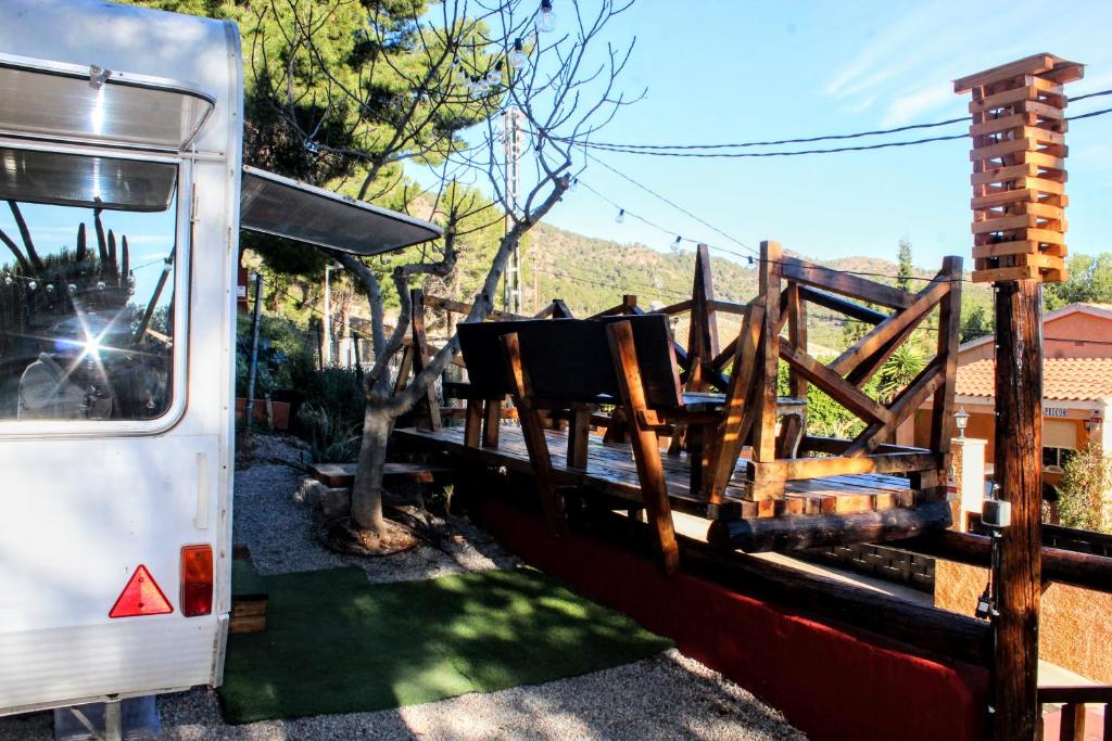 un autobús estacionado junto a una valla de madera en Caravana Vintage Star vistas Mar y Montaña en Náquera