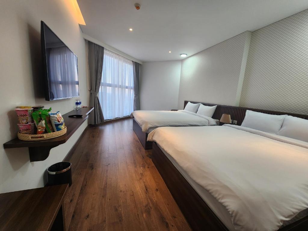um quarto de hotel com duas camas e uma janela em Apec Mandala Mui Ne MD em Ấp Thiẹn Ái