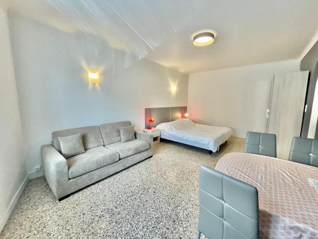 een slaapkamer met een bank en een bed in een kamer bij Themis by Welcome to Cannes in Cannes
