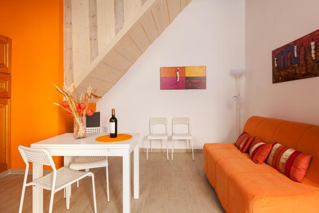 ローマにあるBoccanera a Trastevere Holiday Apartmentのリビングルーム(オレンジ色のソファ、テーブル付)