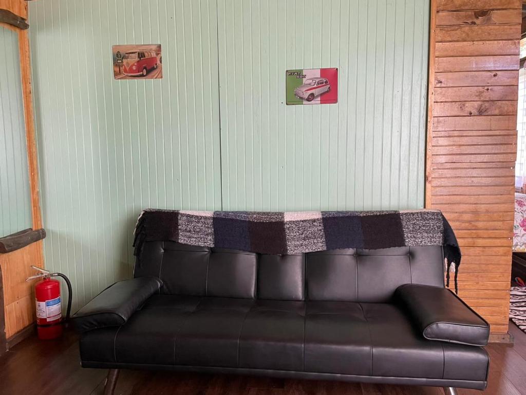 a leather couch with a blanket on top of it at Cabaña de la nona in Futaleufú
