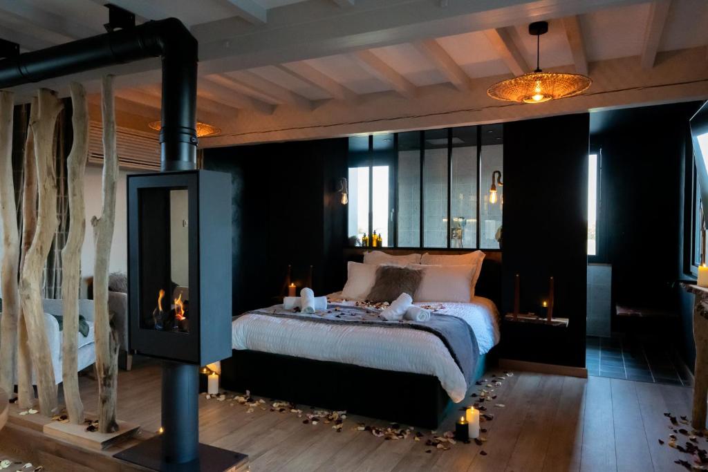 濱海卡約的住宿－Domaine de la Baie de Somme, suite Vanadis，一间卧室配有一张带蜡烛的床和一个壁炉