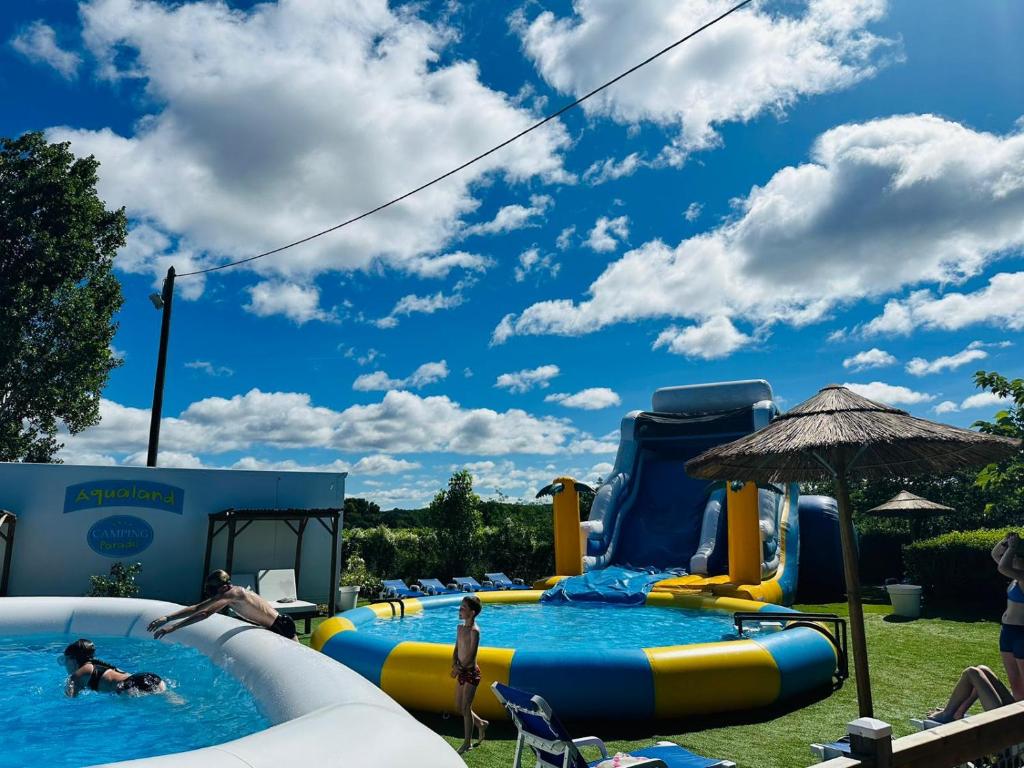 un groupe de personnes jouant dans un parc aquatique dans l'établissement Camping Paradis Family les Rives de l'Hérault, à Gignac