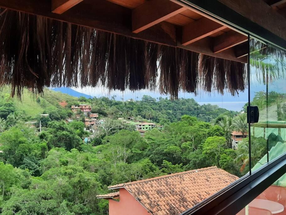 una vista desde la ventana de una casa con árboles en Casa do Zabumba, en Ilhabela