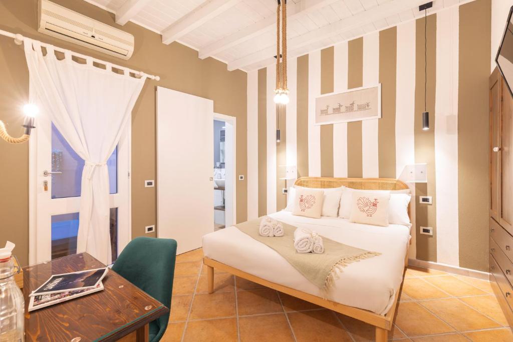 a bedroom with a bed and a table and a desk at Cagliari Old Town B&B in Cagliari