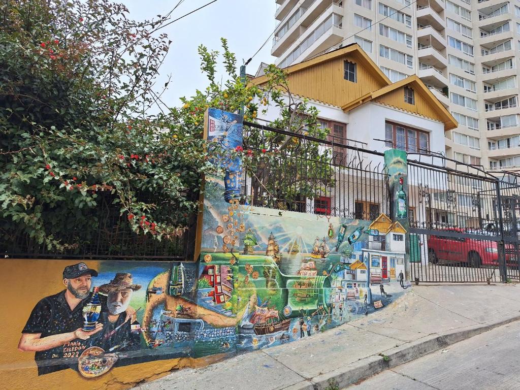Un dipinto di un uomo con un cane su un muro di Casa Avenida Alemania a Valparaíso