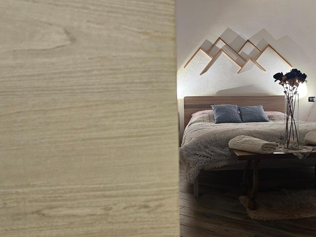 ニュスにある"Traineau"alloggio in villa tipicaのベッドと花が飾られたテーブルのある寝室