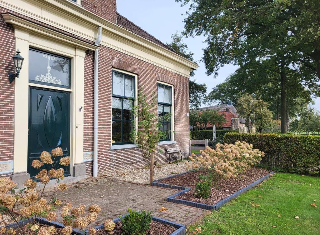 een huis met een tuin ervoor bij De Bloesemstee - Rustic Manor Farmhouse The Netherlands in Ruinerwold