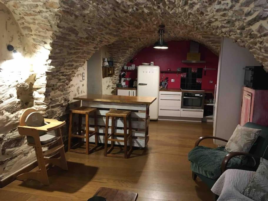 una cucina con tavolo e sedie in una stanza di charmante cave voûtée 4 personnes a Saint-Jean-de-Fos