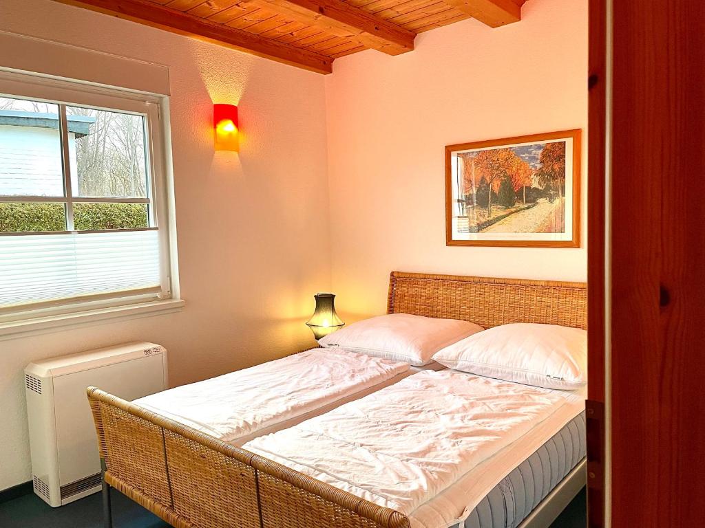 Bett in einem Zimmer mit Fenster in der Unterkunft Ferienhäuser Liethmann Haus 4 W1 in Timmendorf
