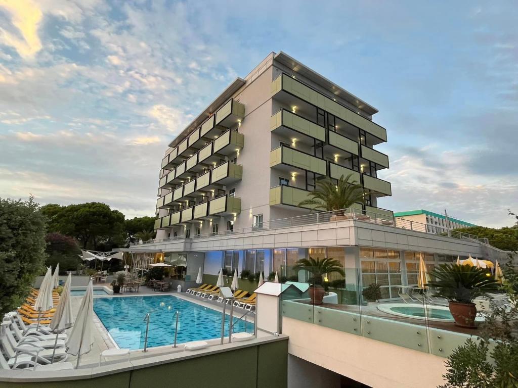 un hotel con piscina frente a un edificio en Hotel Eden en Bibione