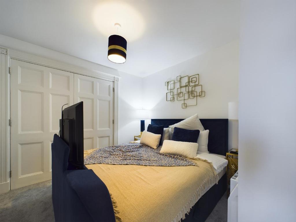 1 dormitorio con 1 cama extragrande con manta amarilla en SunningEnd W King SBed EV Parking, en Cheltenham