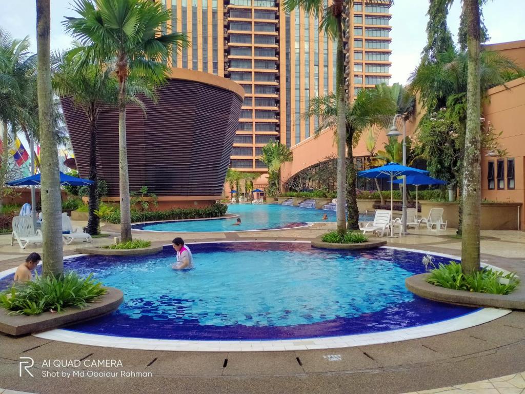a swimming pool at the resort with palm trees at THE ROSEMARY SUITE At TIMES SQUARE in Kuala Lumpur