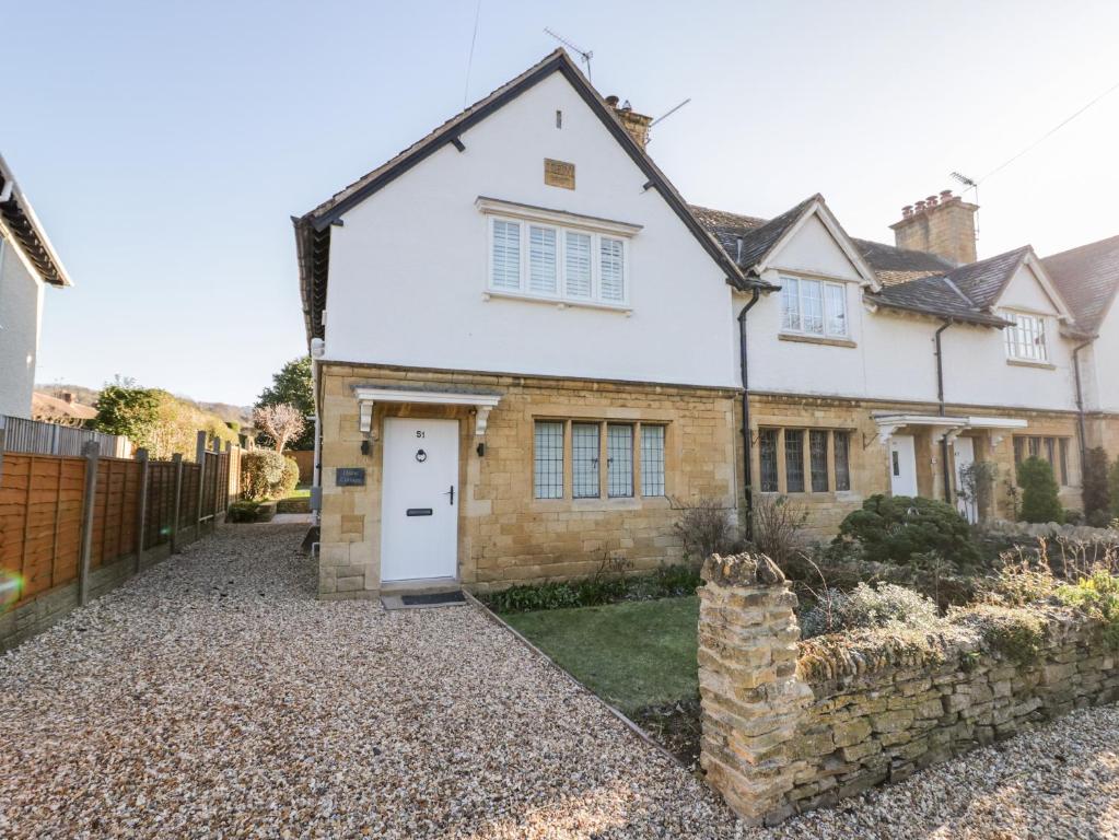 a white house with a white door at Dazie Cottage in Broadway