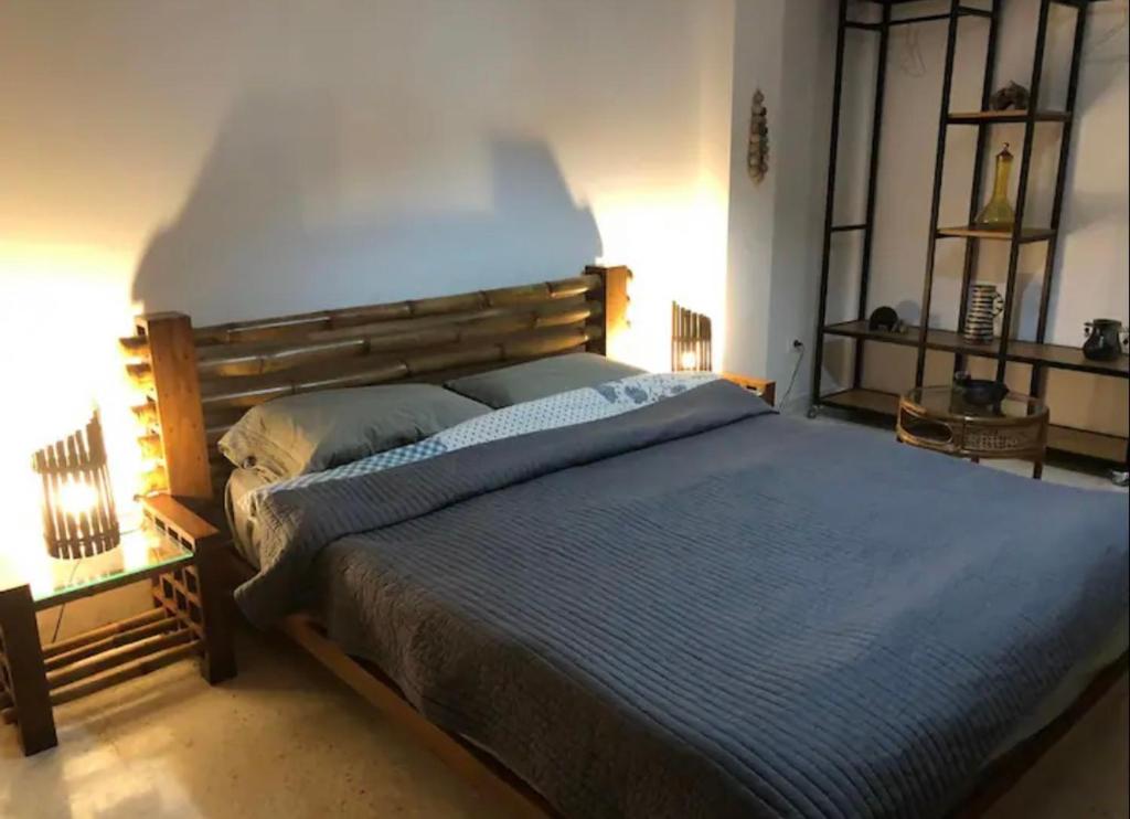 a bedroom with a large bed with a wooden headboard at Superbe chambre dans un appartement à partager in El Aouina