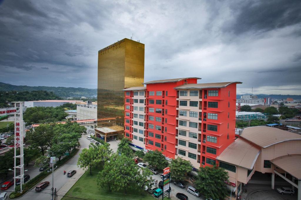 a red building with a tall tower in a city at Limketkai Luxe Hotel in Cagayan de Oro