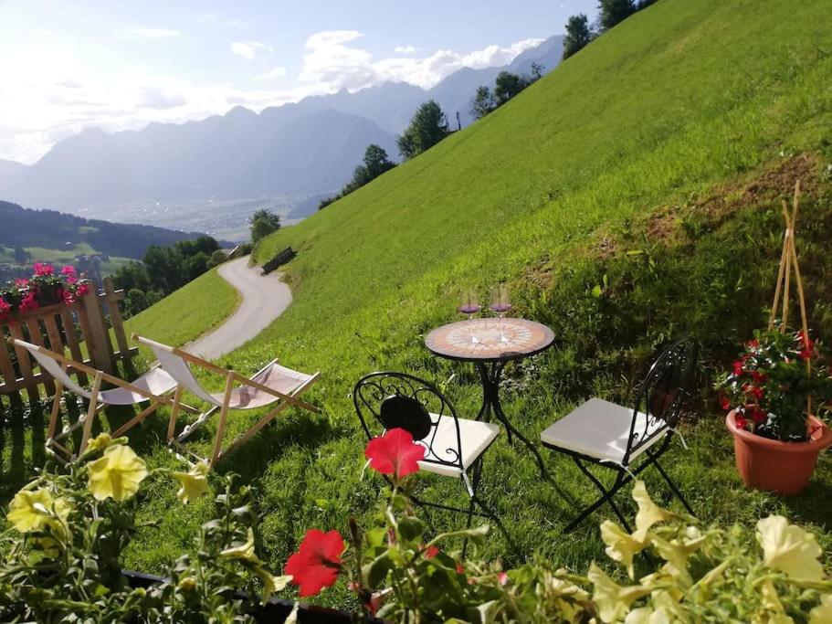 a table and chairs sitting on a hill with flowers at Much`s Bergstüberl in Wattenberg