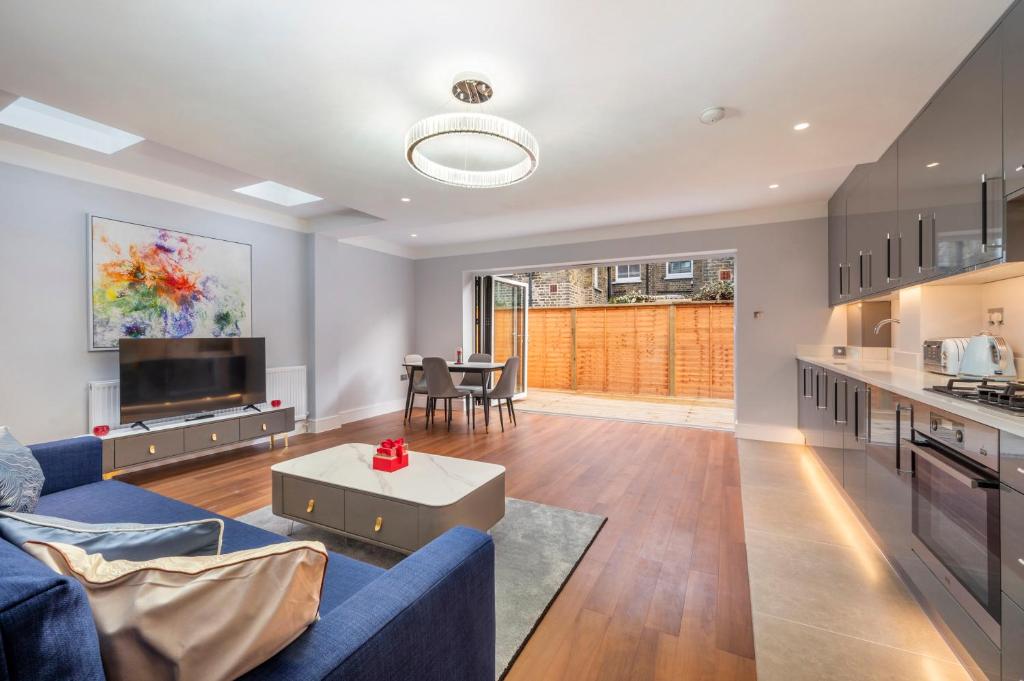 salon z niebieską kanapą i kuchnią w obiekcie Luxury Apartments Victoria, London Eye, Big Ben w Londynie