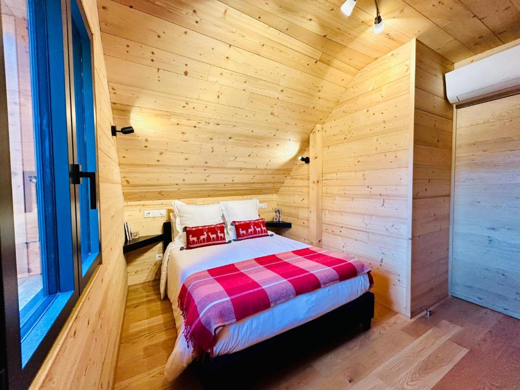 1 dormitorio con 1 cama en una cabaña de madera en Au Pied de l'Arcluse, terrasses et jardin - CLG - Savoie Bauges - 2 CH, en Chevillard