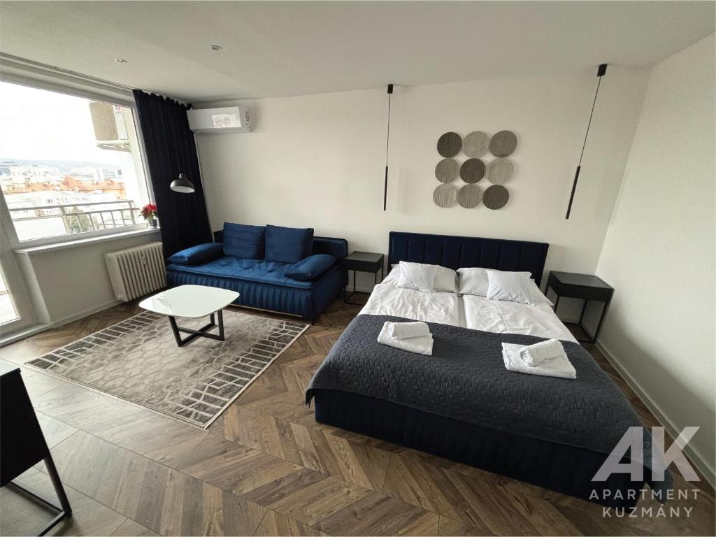 1 dormitorio con 1 cama y 1 sofá azul en Apartment Kuzmany, en Košice