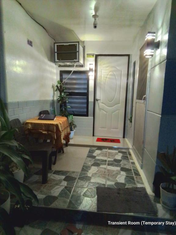 a room with a door and a table and a floor at Parayno's Residence in Manila