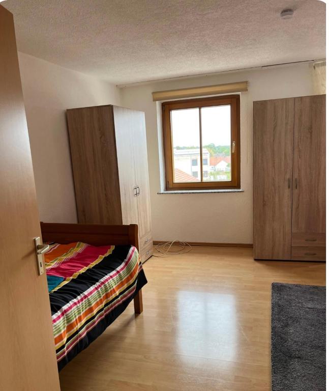 pusty pokój z łóżkiem i oknem w obiekcie Ganzes Haus in der Natur w mieście Lauingen