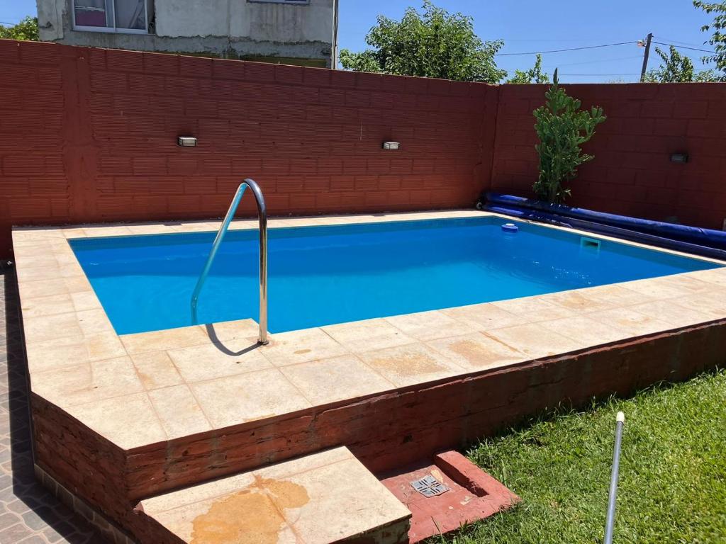 a swimming pool with a brick wall at Casa quinta El Descanso in General Rodríguez