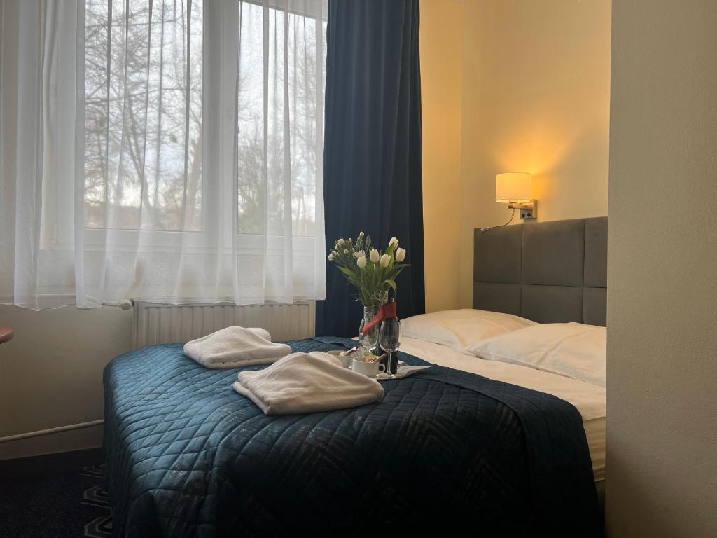 sypialnia z dwoma łóżkami i wazonem kwiatów na stole w obiekcie Hotel Vistula w Krakowie