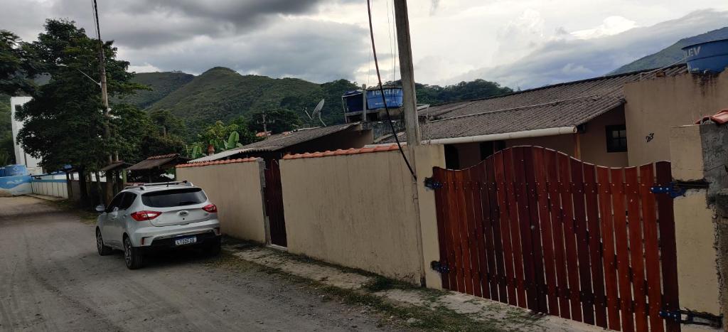 ein Auto, das auf einer unbefestigten Straße neben einem Zaun parkt in der Unterkunft Casa Rota dos Vales in Miguel Pereira