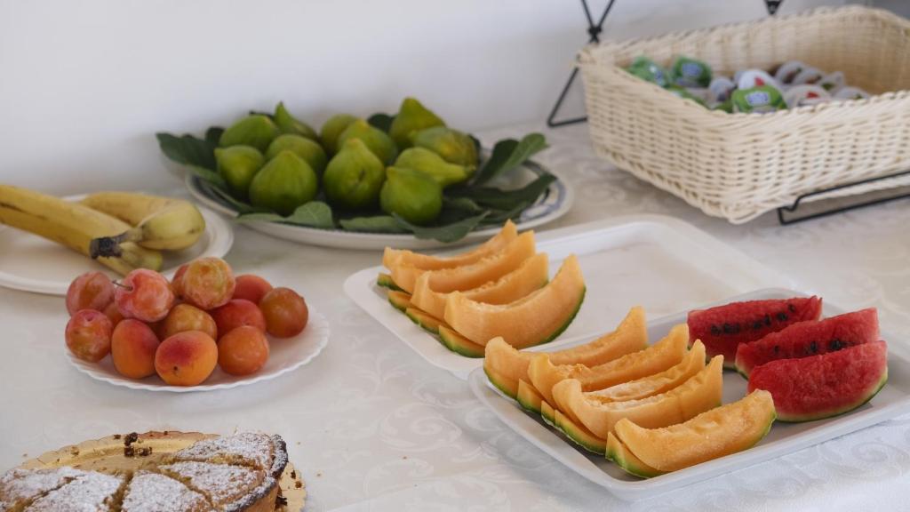 una mesa cubierta con platos de comida con fruta en Bed & Breakfast Villa Michela Alezio, en Alezio