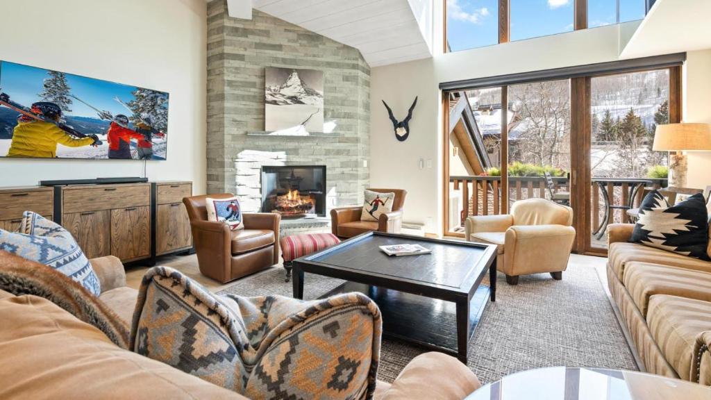 a living room with couches and a fireplace at Skijor Chalet in Vail