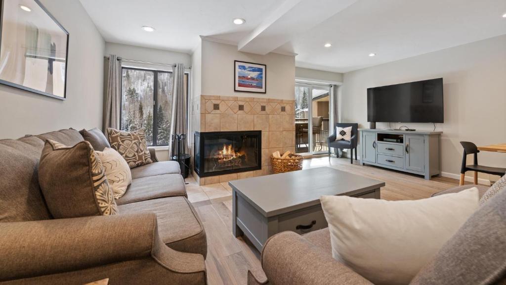 a living room with a couch and a fireplace at Alpinewood Chalet in Vail