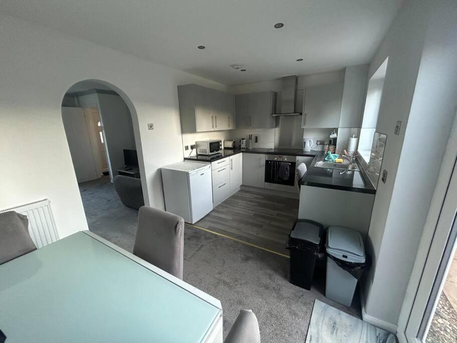 a kitchen with white appliances and a table and chairs at Quiet location 2 bed house 