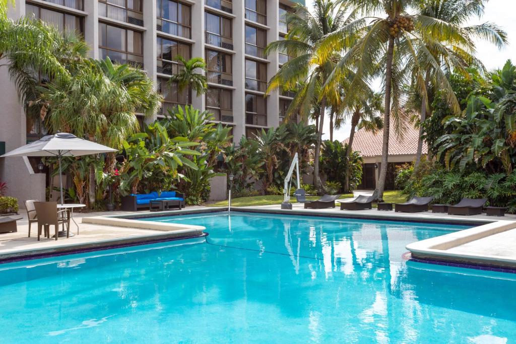 una piscina di fronte a un hotel con palme di 88 Palms Hotel & Event Center a West Palm Beach
