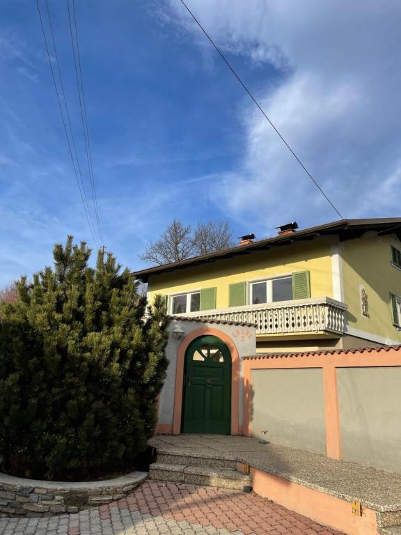 a house with a green door and a driveway at Meli's Zirbenbett Ferienappartment in Bernstein