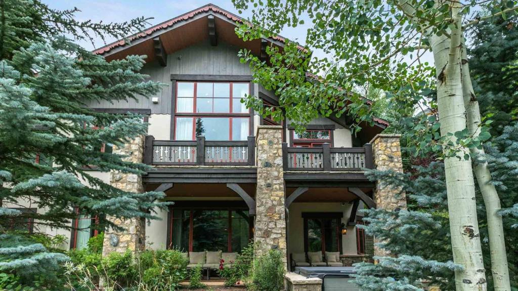 a large house with a balcony and trees at Bergrose Lodge in Vail