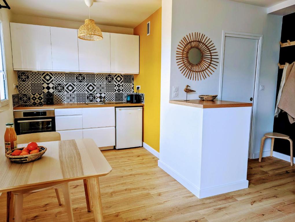 a kitchen with white cabinets and a table at GLAZIK - Studio - Lumineux - Parking in Vannes