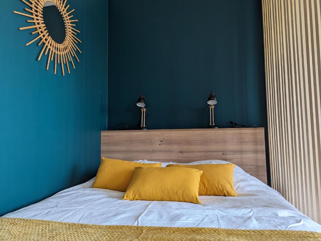 a blue bedroom with a bed with yellow pillows at GLAZIK - Studio - Lumineux - Parking in Vannes