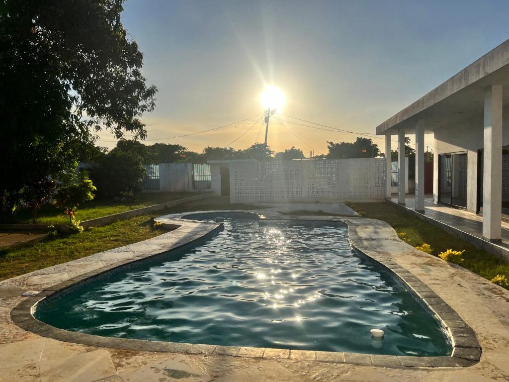 una piscina de agua con el sol en el fondo en Txumas, en Maputo