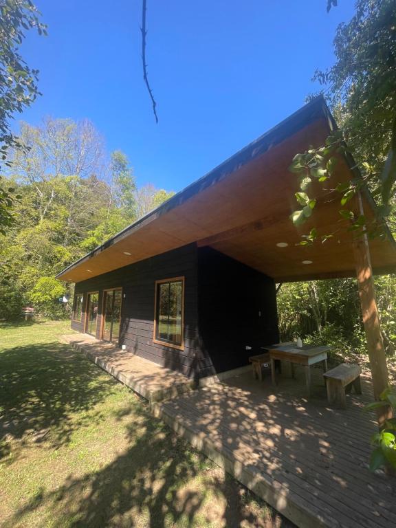 een gebouw met een picknicktafel ervoor bij Pucura Eco Lodge in Licán Ray