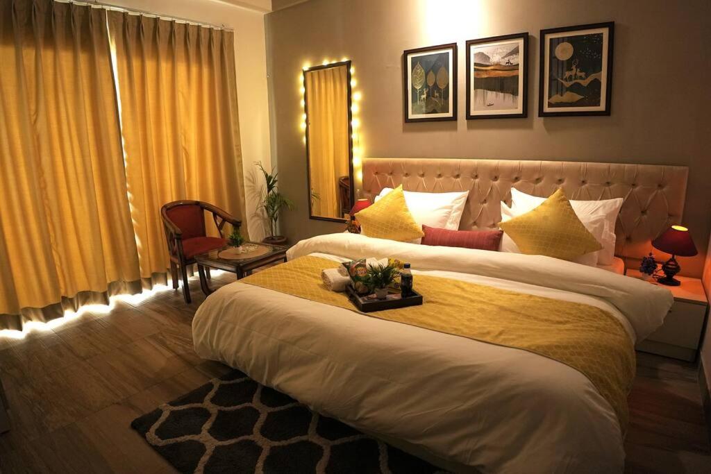 a hotel room with two beds and a window at Luxury Apartment Near Pari Chowk in Greater Noida