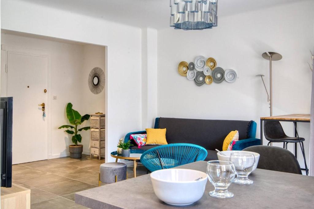 ein Wohnzimmer mit einem Tisch und blauen Stühlen in der Unterkunft Sainte-Catherine - Superbe appartement avec balcon Vieux-Port in Marseille