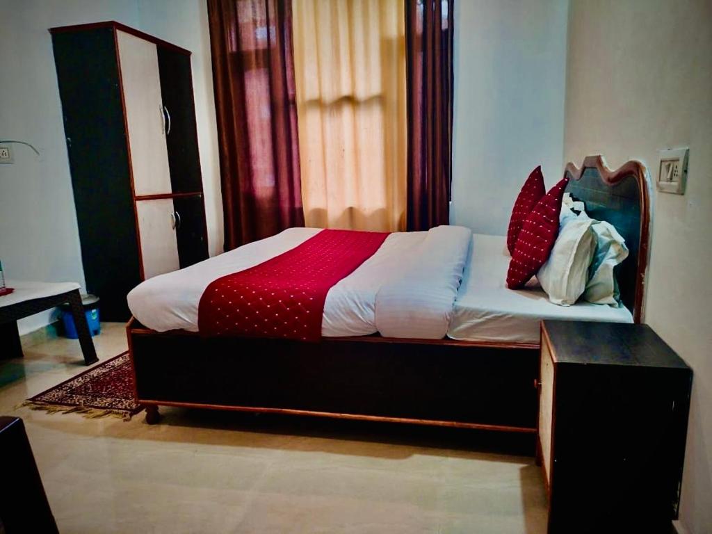 1 dormitorio con 1 cama con manta roja y blanca en Lake Cottage,Mcleodganj, en McLeod Ganj