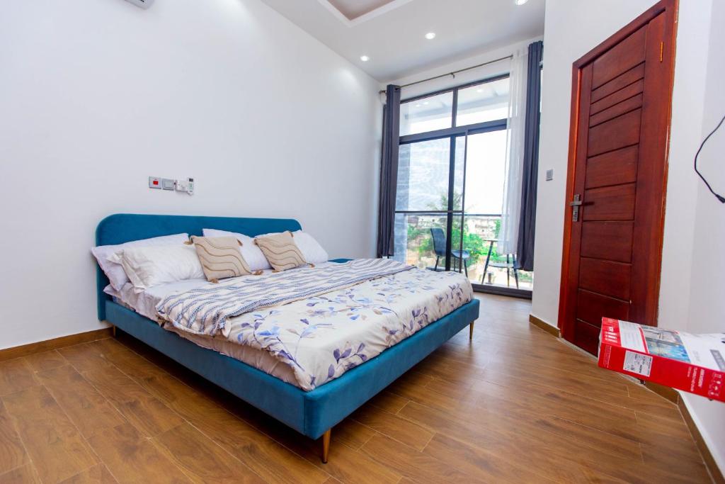 東勒貢的住宿－2 bedroom at East Legon, excellent location，一间卧室设有蓝色的床和大窗户