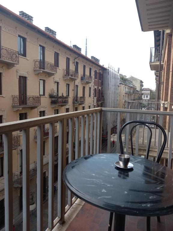 a table on a balcony with a view of a building at La Perla di Vanchiglia (500 meters from the Mole) in Turin